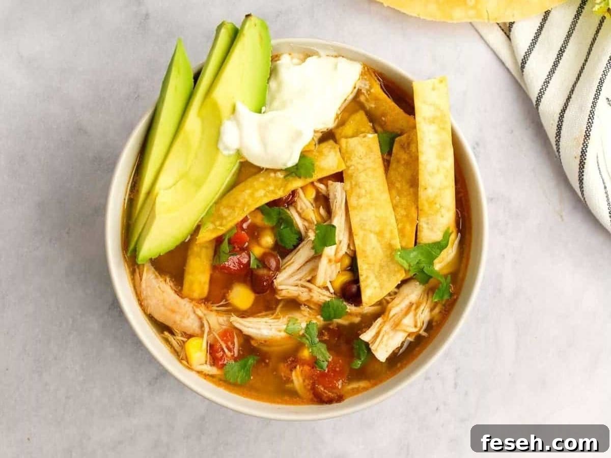 Instapot Chicken Tortilla Soup Bowl of Instant Pot Chicken Tortilla Soup topped with avocado, lime, and tortilla strips.