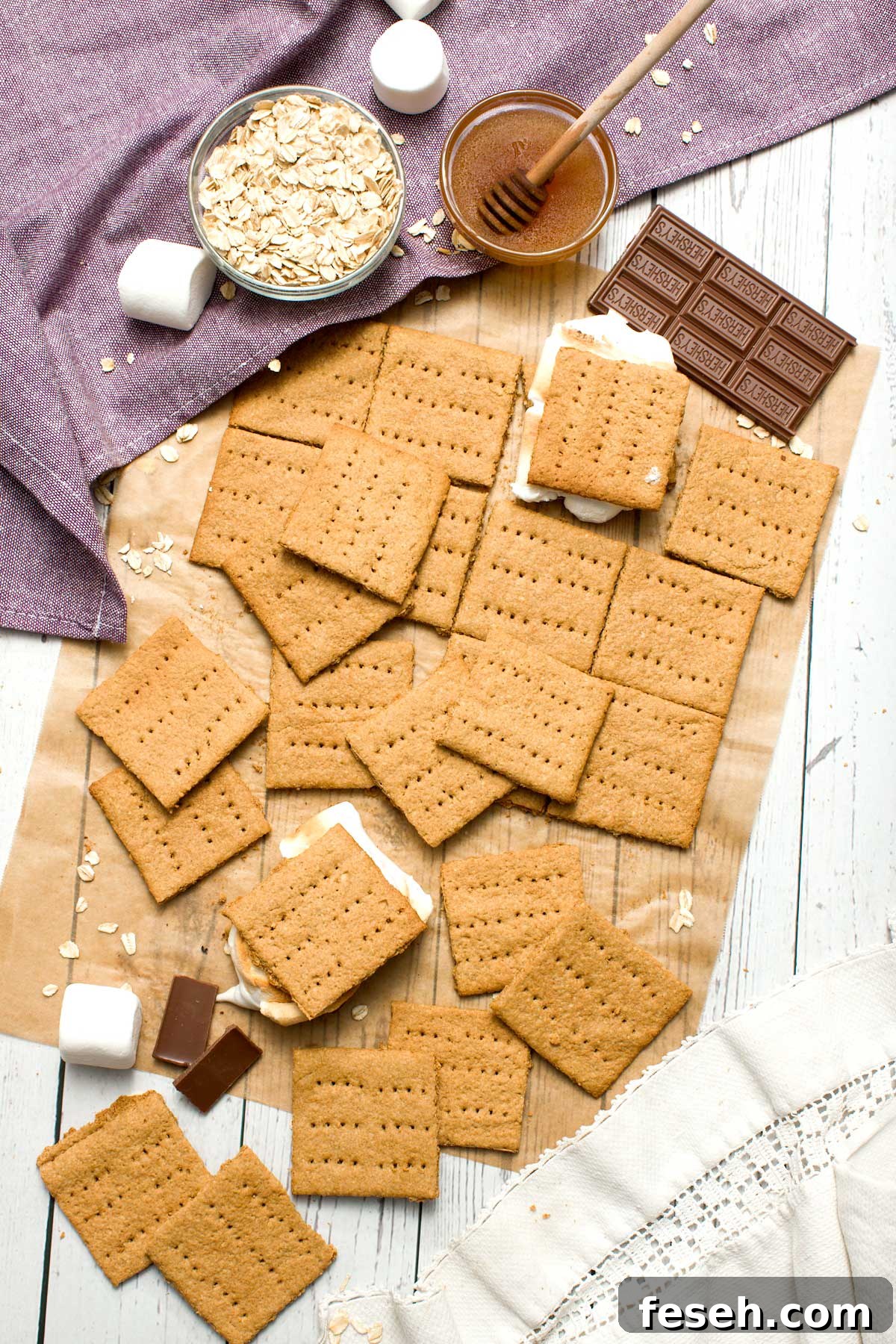 Homemade Gluten-Free Graham Crackers with Oat Flour 5 A batch of gluten-free graham crackers with oat flour and honey with a smores in the middle.