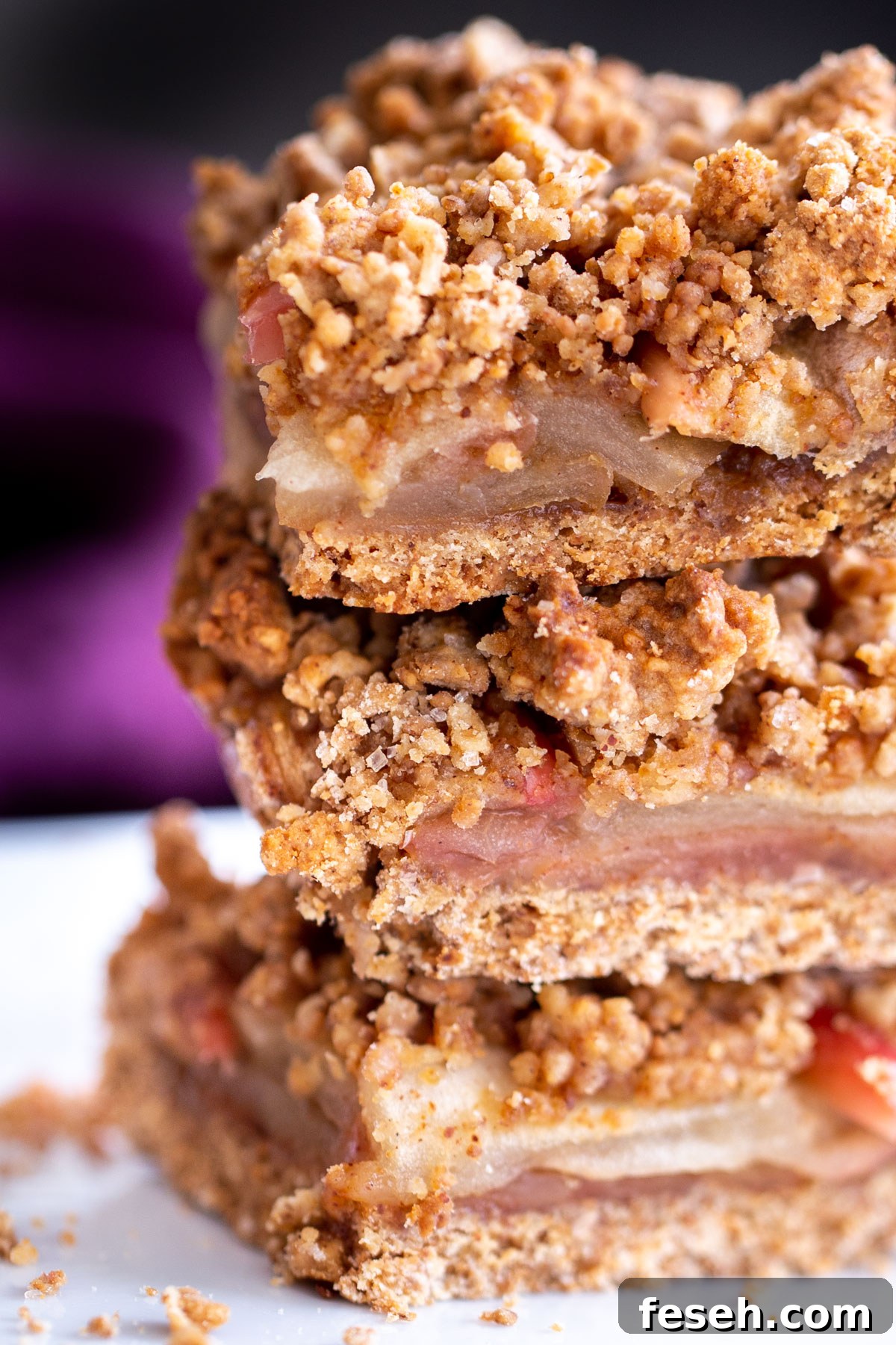 Vegan Apple Pie Bars with Cinnamon Streusel 3 vegan apple pie crumble bars stacked on a plate