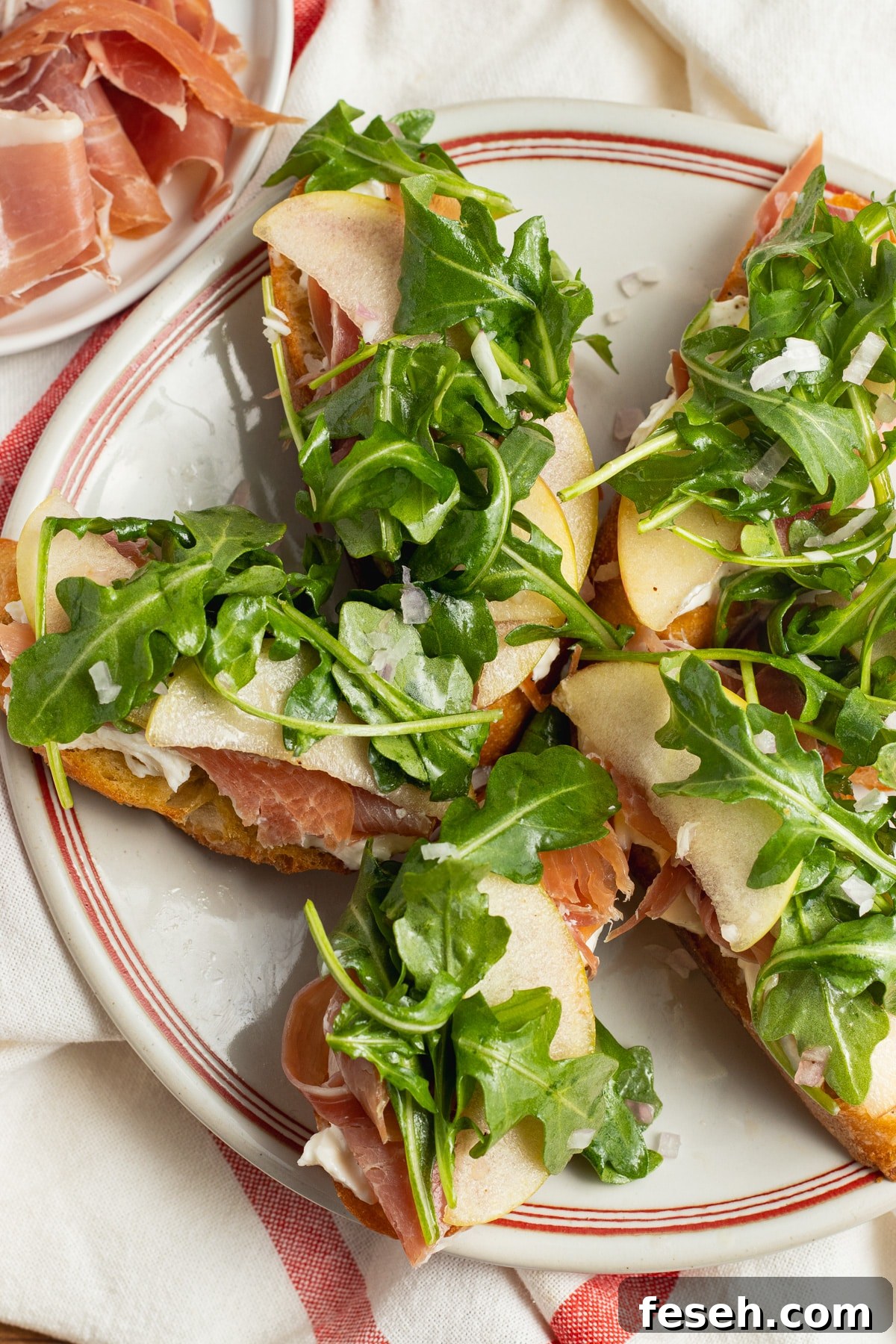 Crispy Crostini Topped with Burrata and Prosciutto 6 This is a picture of a plate with burrata crostini with prosciutto.