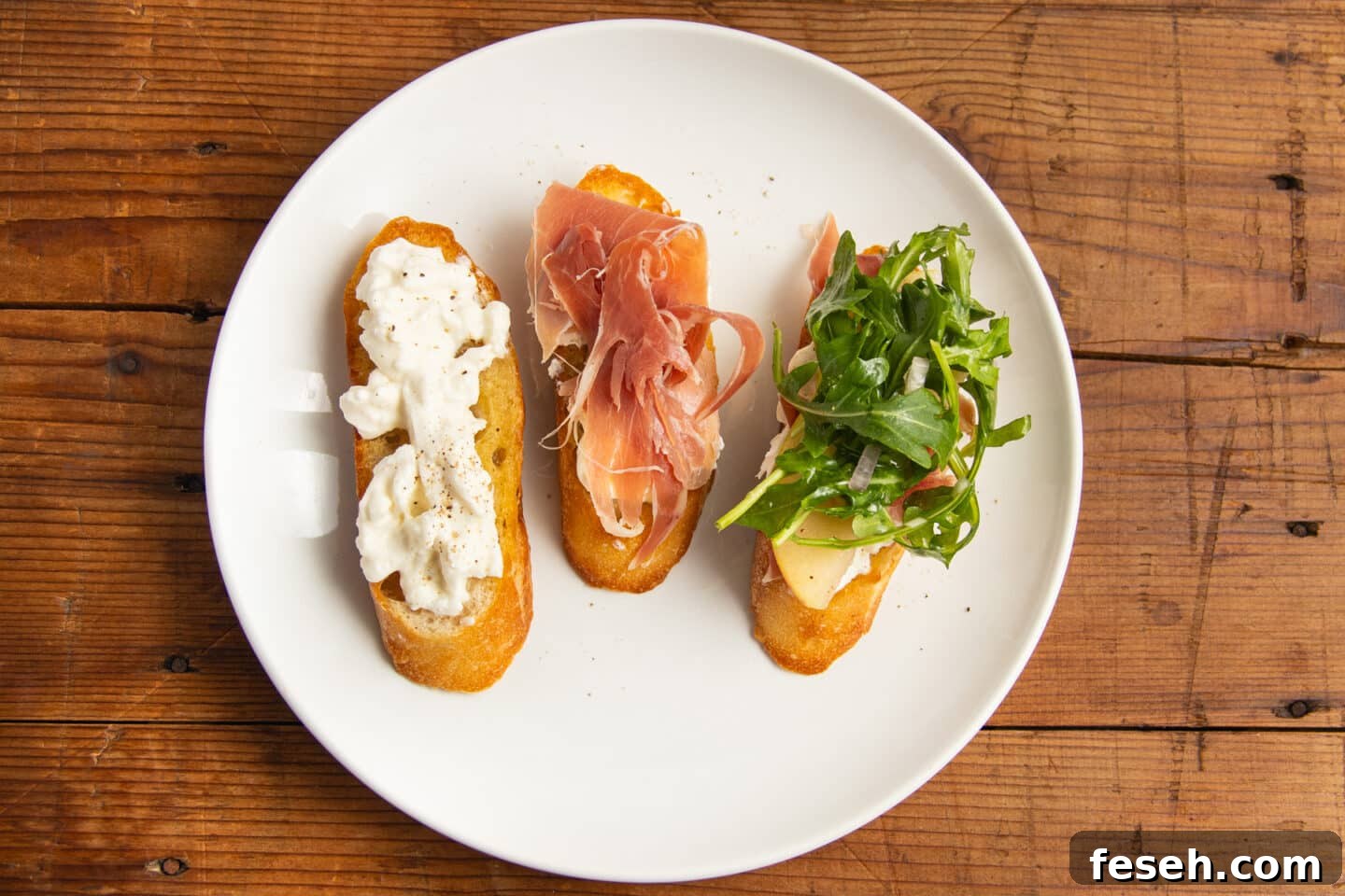 Crispy Crostini Topped with Burrata and Prosciutto 5 This is a picture of the burrata crostini being assembled.