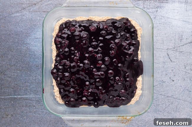No Added Sugar Blueberry Pie Bars Recipe 11 Dough topped with blueberries in a baking dish.