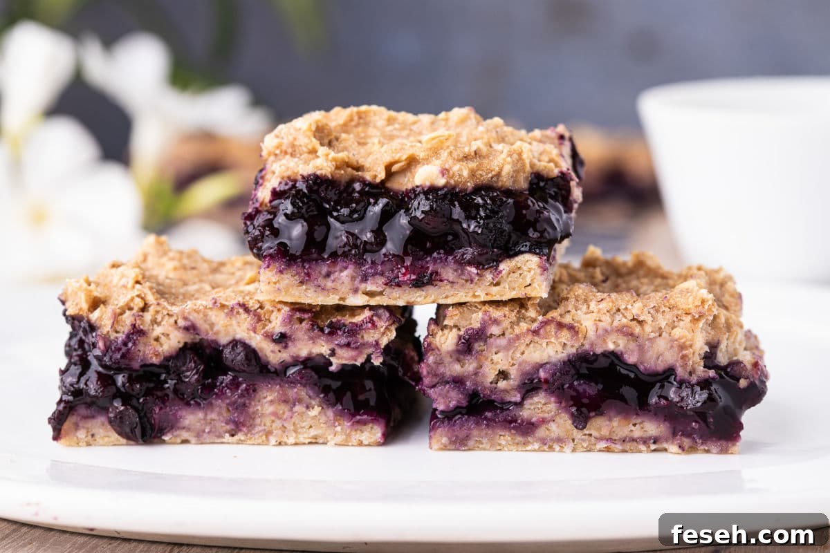 No Added Sugar Blueberry Pie Bars Recipe 13 Stack of three blueberry pie bars on a plate.